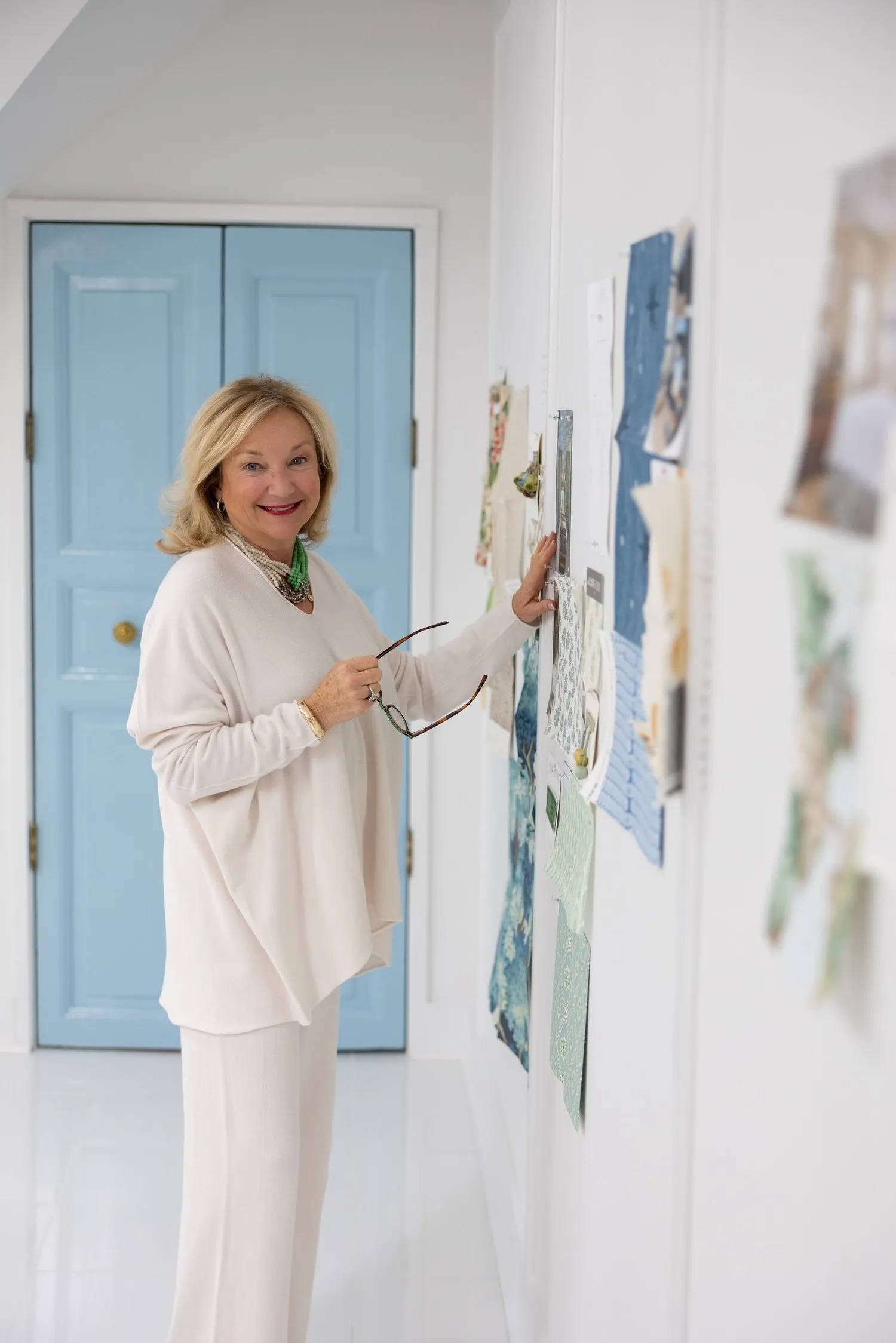 Kathy Patton in the studio, pinning fabric to the sample wall.