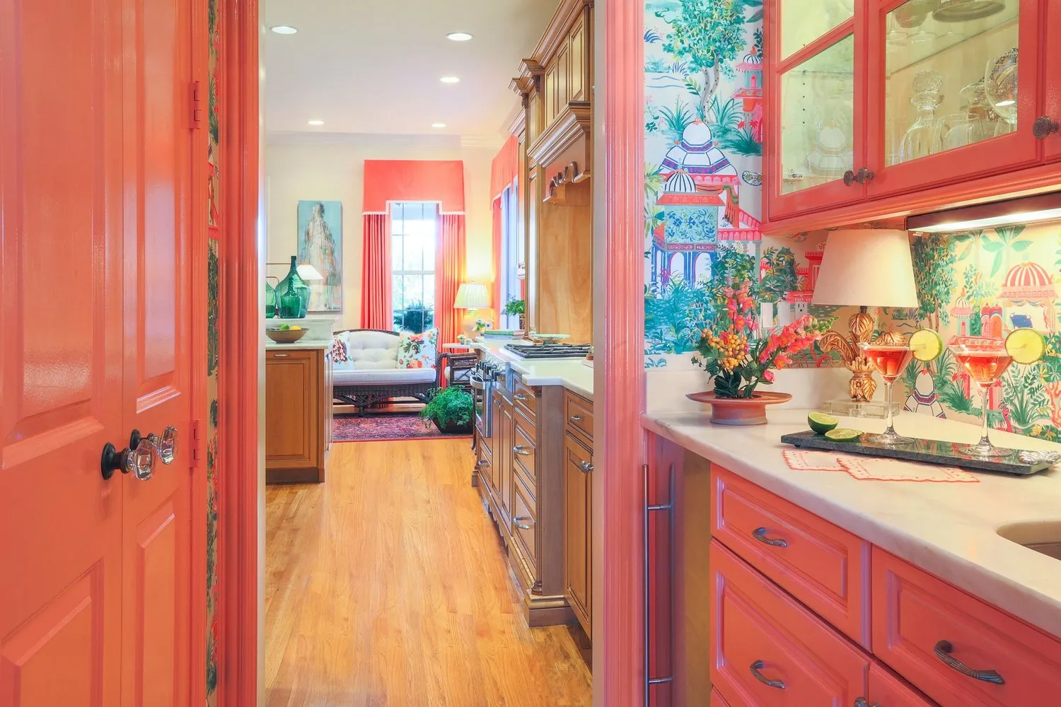 Intown Residence: a coral lacquered butler's pantry opening to the kitchen, papered in a painted chinoiserie.