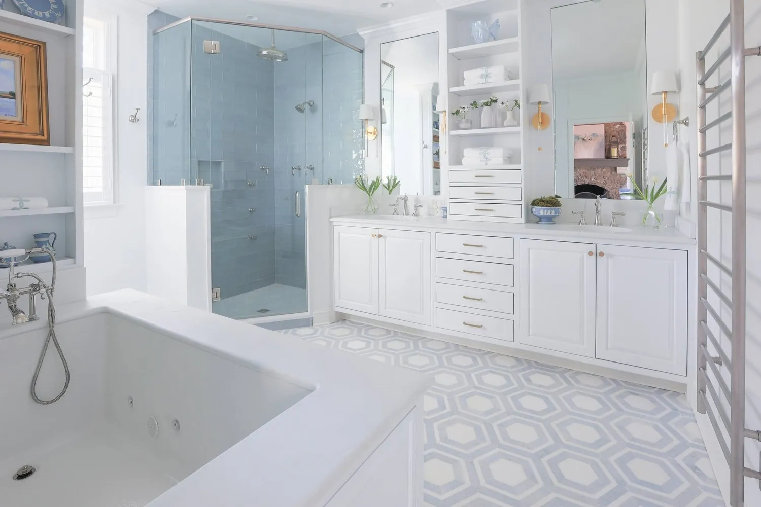 A primary bath with a soaking tub, glass shower and patterned tile floor.